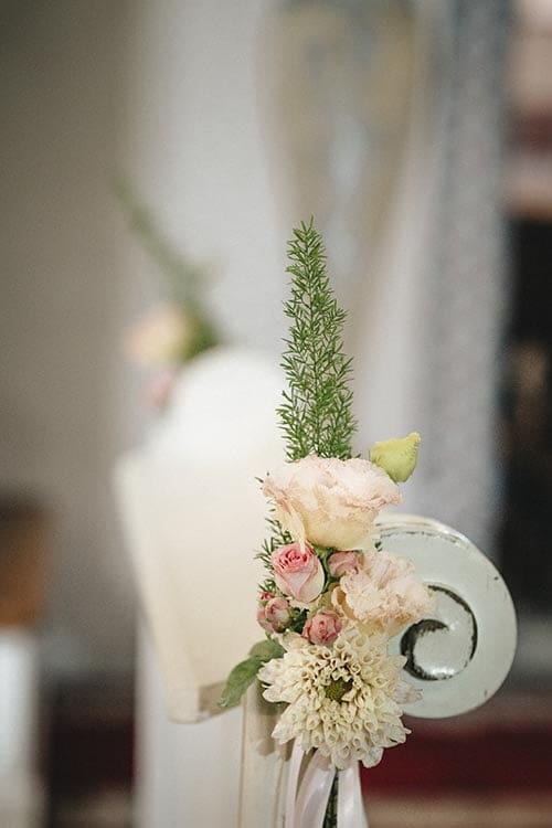 Dekoracje białych klęczników w kościele