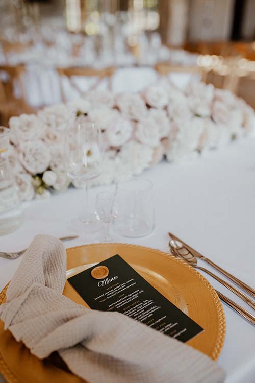 Kompozycja z kwiatów na stół prezydialny, złote podtalerze i menu